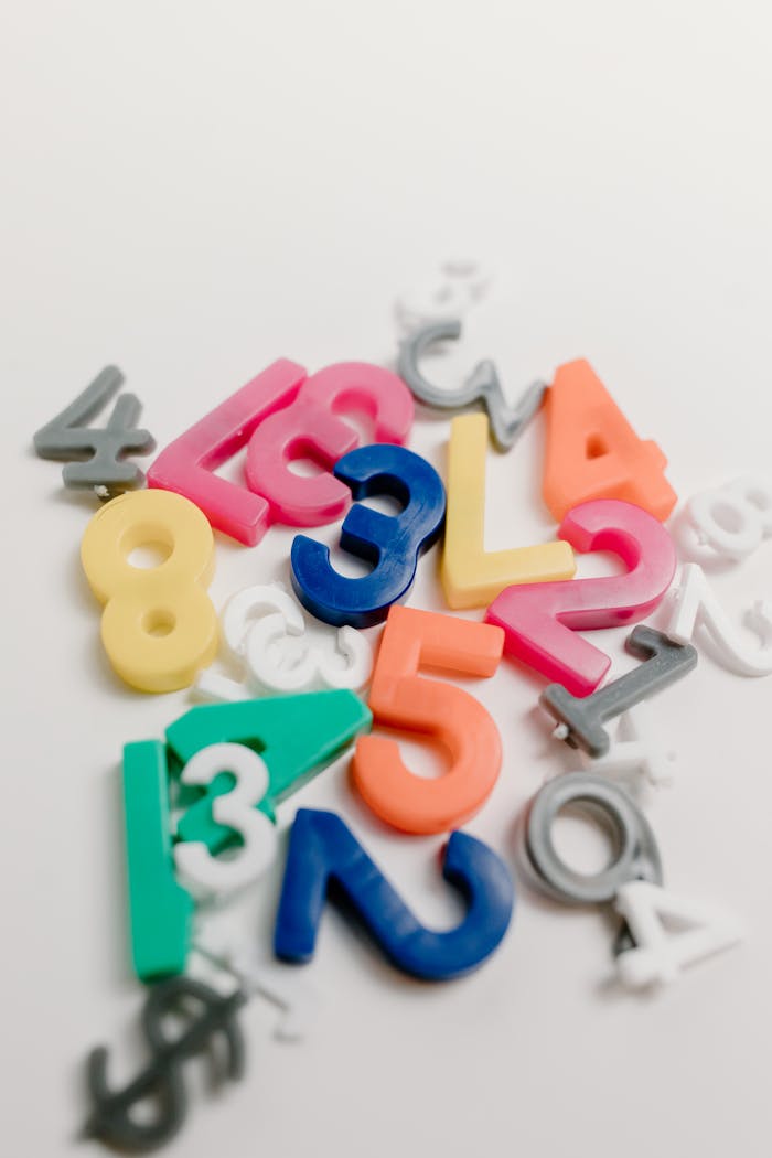 Vibrant plastic numbers scattered on a white background, ideal for educational themes.